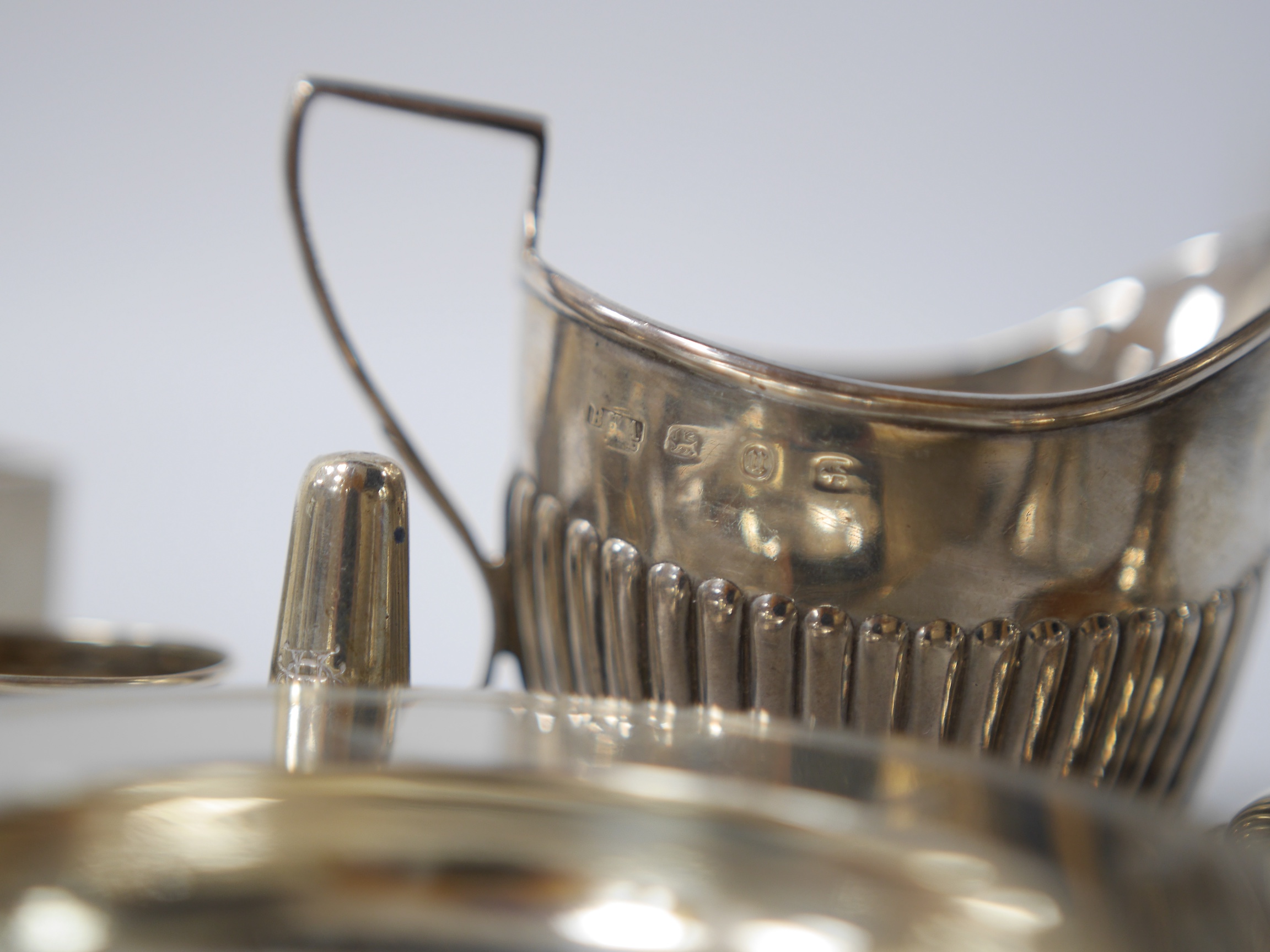 Small silver including two cream jugs, one demi-fluted, Birmingham, 1894, a dish, a dwarf candlestick, napkin rings, toilet jars, stopper, pepperette and extinguisher. Condition - poor to fair to good